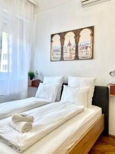 um quarto com 2 camas e lençóis brancos em Standard Apartment by Hi5- Aranykéz Studio em Budapeste