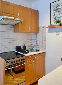 uma cozinha com armários de madeira, um lavatório e um frigorífico em Standard Apartment by Hi5- Aranykéz Studio em Budapeste