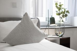 poduszkę siedzącą na łóżku z oknem w obiekcie ma suite - smart apartment 2P - city Center w Augsburgu