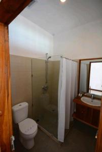 y baño con aseo, ducha y lavamanos. en Hotel Sanset, en Labuan Bajo