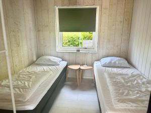 a small room with two beds and a window at Boerenslag 24 in Sint Maartensvlotbrug