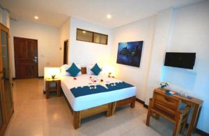een slaapkamer met een groot bed en een tafel bij Hotel Sanset in Labuan Bajo