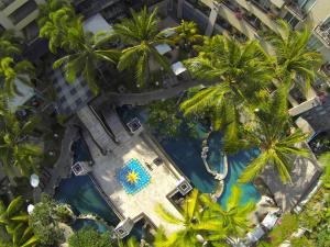 einen Blick über einen Pool mit Palmen in der Unterkunft Kuta Paradiso Hotel in Kuta