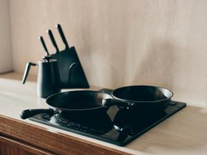 two frying pans sitting on a tray on a counter at illi Com Shimokitazawa in Tokyo