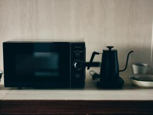 a microwave sitting on a counter next to a blender at illi Com Shimokitazawa in Tokyo