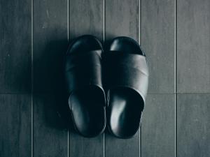 a pair of black shoes sitting on a tile floor at illi Com Shimokitazawa in Tokyo