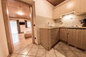a large kitchen with wooden cabinets and a hallway at Mösslhof App Wiese in San Vito
