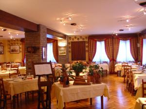 a dining room with white tables and chairs at Hotel Dei Camosci in Courmayeur