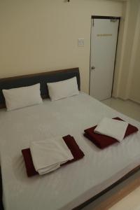a bed with two white towels on top of it at Antique Home Stay in Daman