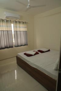 een slaapkamer met een bed met witte lakens en een raam bij Antique Home Stay in Daman