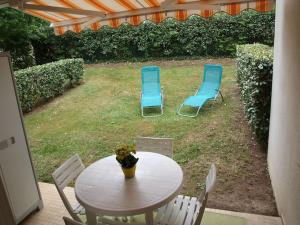 2 Stühle und ein Tisch und Stühle im Hof in der Unterkunft Appartement terrasse jardin rive gauche du port in Vannes
