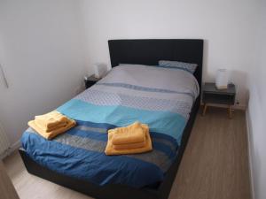 ein Schlafzimmer mit einem Bett mit zwei Handtüchern darauf in der Unterkunft Appartement terrasse jardin rive gauche du port in Vannes