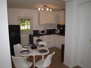 une cuisine avec une table et des chaises dans l'établissement Appartement terrasse jardin rive gauche du port, à Vannes