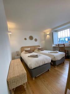 a room with two beds and a table in it at Casa da Corredoura in Évora
