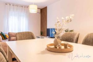 a room with a table with chairs and a vase on it at A estrenar pleno centro, parking in Huelva +36 photos