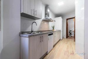 a kitchen with white cabinets and a sink at A estrenar pleno centro parking in Huelva