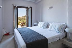 sypialnia z dużym łóżkiem i dużym oknem w obiekcie Villa Faros Vourkari Kea with private pool and stunning views w mieście Vourkari