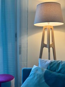 eine Lampe im Wohnzimmer mit blauem Sofa in der Unterkunft Seaview apartment Cala de Finestrat - Vista al mar in Villajoyosa