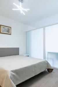 a white bedroom with a bed and a window at Casa Mazzini 156b in Ancona