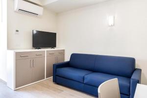 a blue couch in a room with a flat screen tv at Casa Mazzini 156b in Ancona