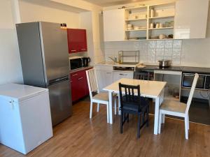 a kitchen with a table and chairs and a refrigerator at Appartement 3 pièces AlfortVille Centre in Alfortville