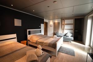 a bedroom with two beds and a couch at Eurobody in Tielt +8 photos