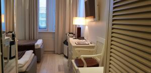 ein Hotelzimmer mit einem Schreibtisch und einem Bett in der Unterkunft Best Western Hotel Apollo in Oulu