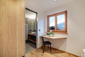 a small bathroom with a desk and a window at Huetterhof Apartement Winter in Caines +13 photos