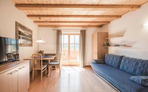 a living room with a blue couch and a table at Karerhof in Nova Levante