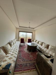 sala de estar con sofá grande y mesa en Cosy appartement, en Nouaceur