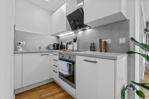 a white kitchen with white cabinets and appliances at ma suite -NEW-23Floor-FantasticView-Center in Augsburg