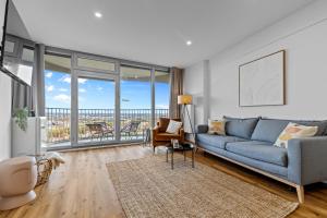 a living room with a blue couch and a balcony at ma suite -NEW-23Floor-FantasticView-Center in Augsburg