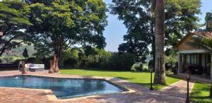 a swimming pool in the yard of a house at SavannaSkies Stays in Hillcrest