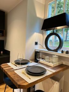 a wooden table with two plates and wine glasses at Premium Apartment an der Stadtmauer im EG in Paderborn