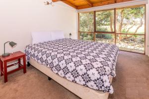 a bedroom with a bed and a table and a window at Prom Coast Oasis - Sandy Point in Sandy Point