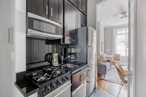 uma cozinha com armários pretos e um forno com placa de fogão em West Village 1br w wd nr local park NYC-1262 em Nova York