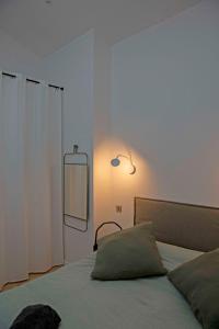 una camera da letto con un letto con uno specchio sul muro di La Petite Échoppe - Chartrons a Bordeaux