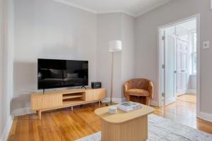a living room with a television and a table at West Village 1br w wd nr park NYC-1275 in New York