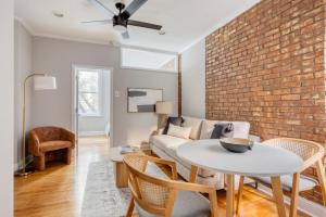 a living room with a brick wall and a table and chairs at West Village 1br w wd nr park NYC-1275 in New York