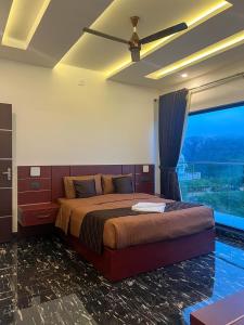 a bedroom with a bed and a large window at Dellamore Havn in Vagamon