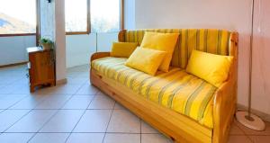 a couch with yellow pillows on it in a room at 150m DALLE PISTE - Parcheggio Gratis in Sella della Turra