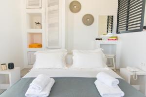 a bedroom with a bed with two towels on it at Lemon Tree Houses in Áno Meriá