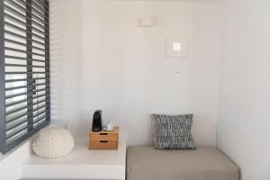 a white room with a chair and a window at Lemon Tree Houses in Áno Meriá
