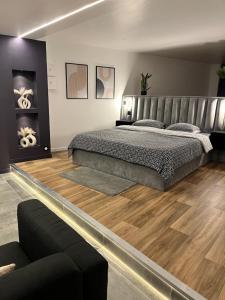 ein Schlafzimmer mit einem großen Bett und Holzböden in der Unterkunft Azulik Spa & Jacuzzi privatif in Gargenville