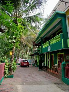 a car parked in front of a green building at Beach Village Holiday Homes Goa in Colva