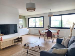 a living room with a blue couch and a table at L'Échappée Belle - Appartement charmant et chaleureux in La Séguinière