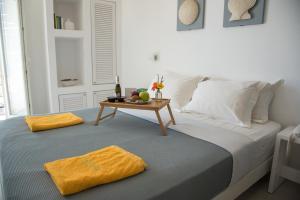 a bed with a table with a tray of fruit on it at Lemon Tree Houses in Áno Meriá