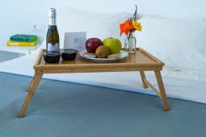 a table with a plate of fruit and a bottle of wine at Lemon Tree Houses in Áno Meriá