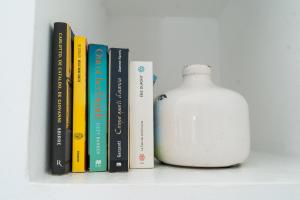 a shelf with several books and a white vase at Lemon Tree Houses in Áno Meriá