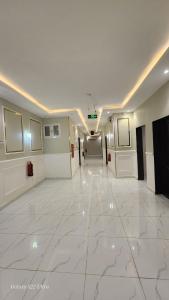 a hallway with a large white tile floor in a building at خيال بارك in Baish